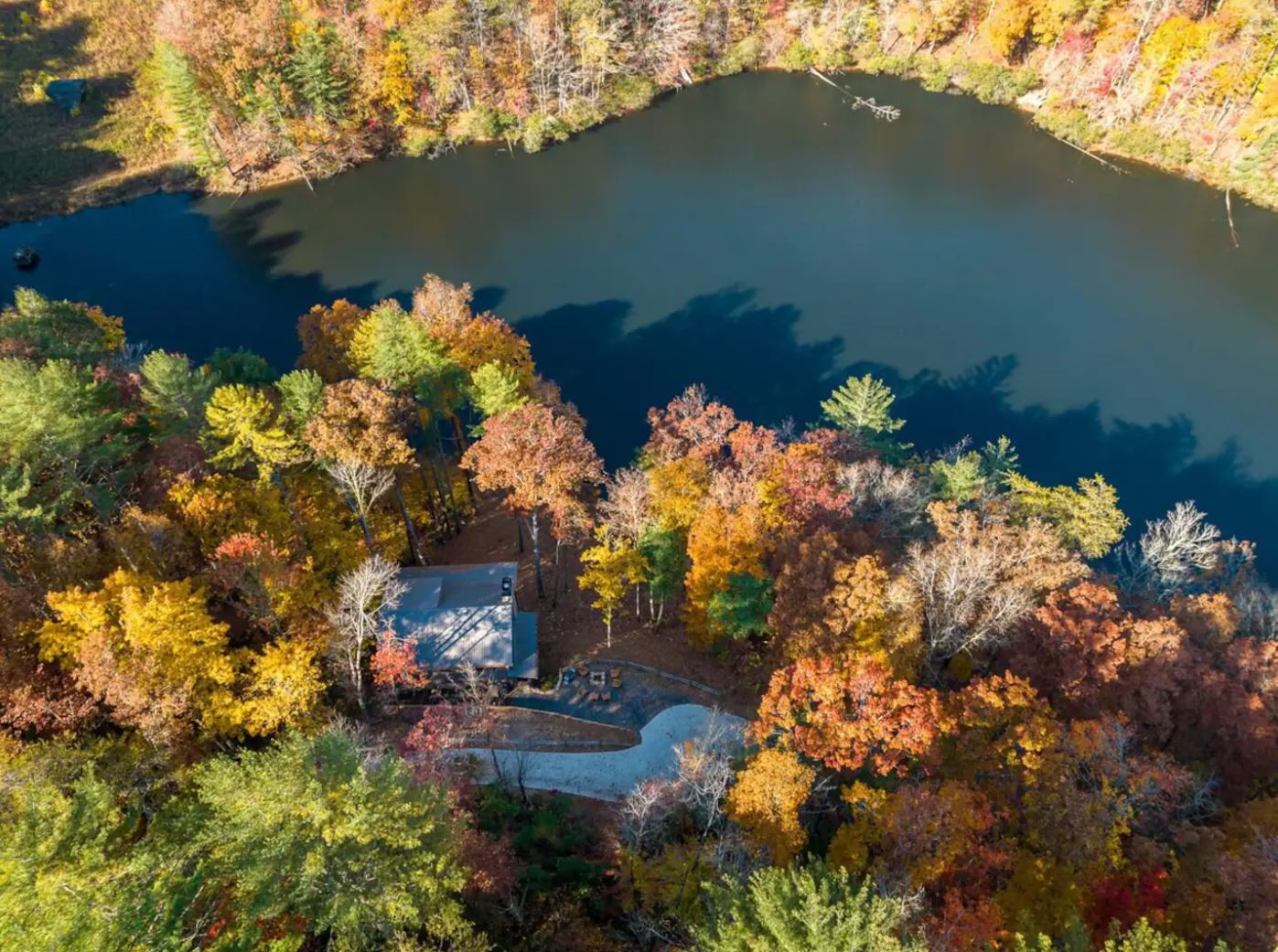 Aerial view of a lakeside Lifestyle Asset cabin in autumn forest — the kind of property Vodyssey members learn to identify